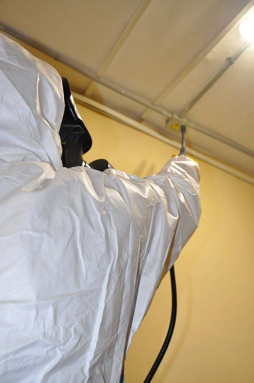 Специалист службы дезинсекции в защитном костюме